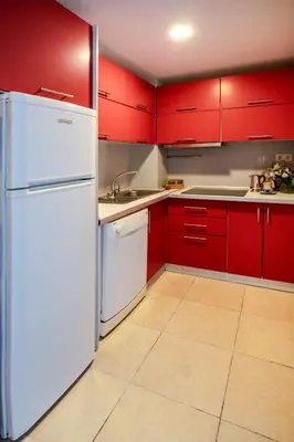a kitchen with red cabinets and a white refrigerator at Cheya Sisli BNB Medical & Business City Center Tesvikiye Suites and Apartments in Istanbul