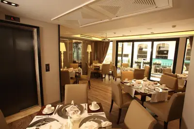 a dining room with tables and chairs and windows at Hotel La Villa in Istanbul