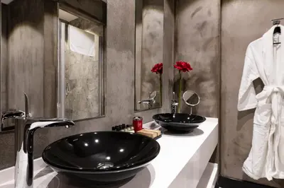 a bathroom with a black sink and two mirrors at Nabu Hotel Karaköy in Istanbul