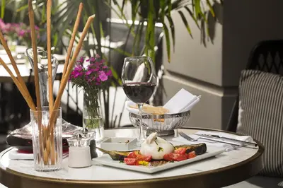 a table with a plate of food and a glass of wine at Nabu Hotel Karaköy in Istanbul