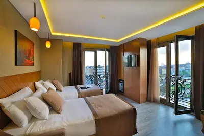 a hotel room with two beds and a balcony at Corner Hotel Laleli in Istanbul