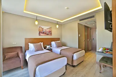 a hotel room with two beds and a couch at Corner Hotel Laleli in Istanbul
