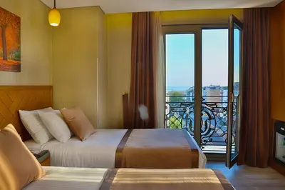 a hotel room with two beds and a balcony at Corner Hotel Laleli in Istanbul