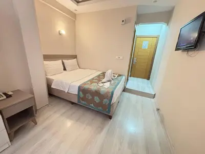a small room with a bed and a phone in it at Fly Hotel in Istanbul