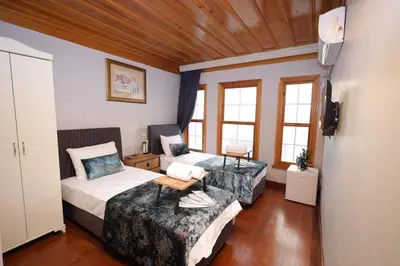two beds in a room with wooden ceilings and windows at The Trip istanbul Hotel in Istanbul