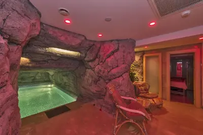 a bathroom with a large rock wall with a swimming pool at Glorious Hotel in Istanbul