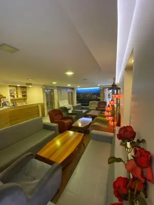 a living room with couches and tables and flowers at Polanin Hotel in Istanbul
