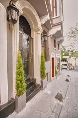 a building with two potted trees in front of a store at Arart Hotel in Istanbul