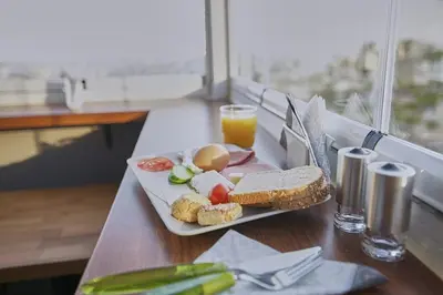 a plate of food with a sandwich and a glass of orange juice at Arart Hotel in Istanbul
