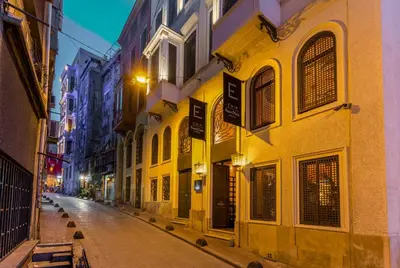 an empty city street at night with yellow buildings at The Wings Hotels Collection in Istanbul