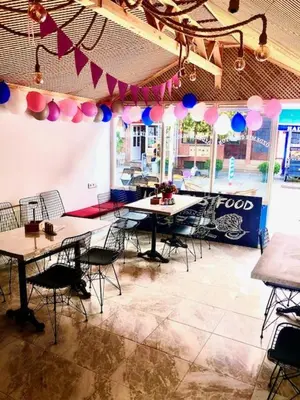 a room with tables and chairs and pink and blue balloons at Ozdemir Pansiyon in Heybeliada