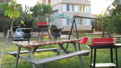 a picnic table with a grill and chairs on it at Sağlık Apart Pansiyon in Erdek