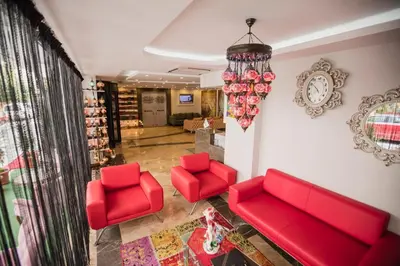 a living room with red furniture and a chandelier at Royal İnci Hotel in Istanbul