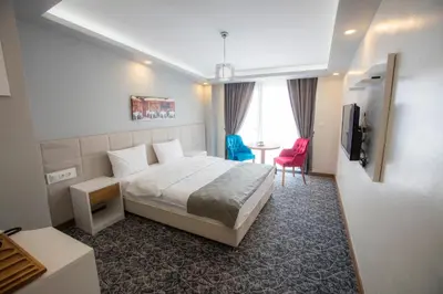 a bedroom with a bed and a table and a tv at Royal İnci Hotel in Istanbul