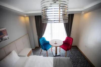 a room with a bed and two chairs and a table at Royal İnci Hotel in Istanbul