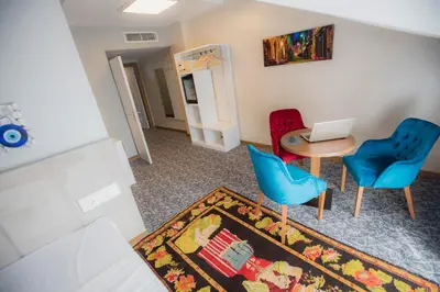 a living room with a table and chairs and a laptop at Royal İnci Hotel in Istanbul