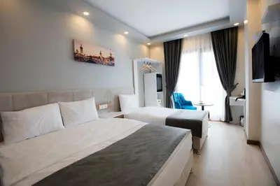 a hotel room with two beds and a desk at Royal İnci Hotel in Istanbul