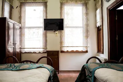 two beds in a room with a tv and two windows at Lal Hotel Bursa in Bursa