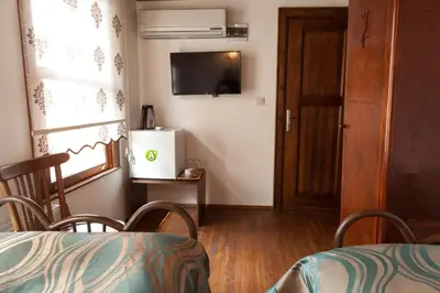 a room with a table and a television and a door at Lal Hotel Bursa in Bursa