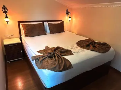 a bedroom with a bed with two robes on it at Modern Sultan Hotel in Istanbul