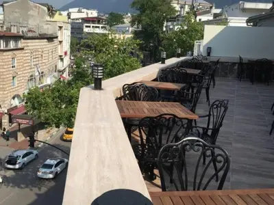 an outdoor seating area with tables and chairs on a balcony at Waha Hotel in Bursa