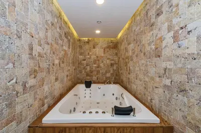 a bath tub in a room with a brick wall at MARE PARK Hotel & SPA in Istanbul