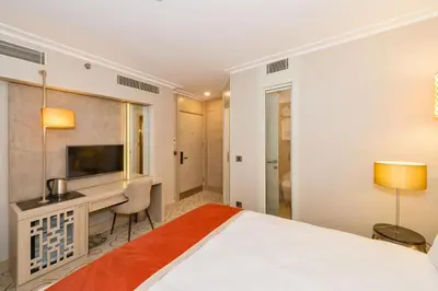 a bedroom with a bed and a desk and a television at MARE PARK Hotel & SPA in Istanbul