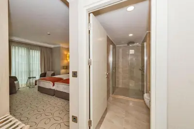 a bathroom with a shower and a bedroom with a bed at MARE PARK Hotel & SPA in Istanbul