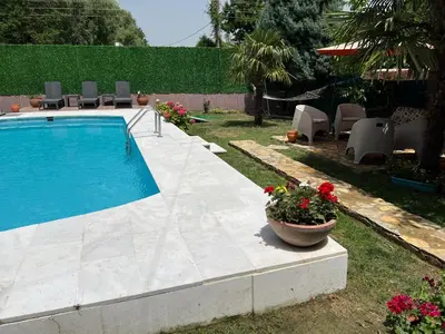 a swimming pool with a pot of flowers in a yard at Villa Onuk in Sapanca