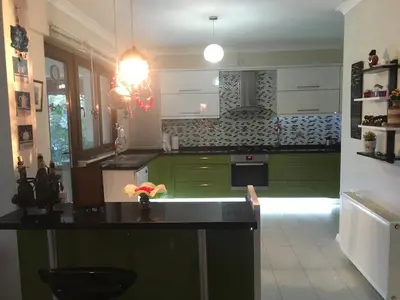 a kitchen with green cabinets and a black counter top at Villa Onuk in Sapanca