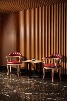two chairs and a table in front of a wooden wall at Metropolitan Hotels Bosphorus - Special Category in Istanbul