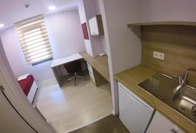 a small kitchen with a sink and a desk at Uçar Royal Hotel ve Konferans Salonu in Sile