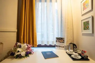 a desk with a book and flowers on it in front of a window at Tiara Buyukada in Buyukada