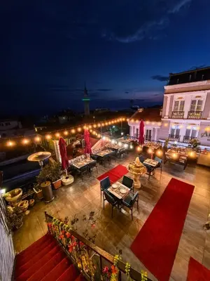 a rooftop patio with tables and lights at night at Apple Tree Hotel in Istanbul