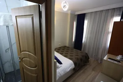 a bedroom with a bed and a door with a window at Arven Hotel in Istanbul