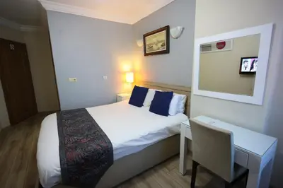 a small hotel room with a bed and a desk at Arven Hotel in Istanbul
