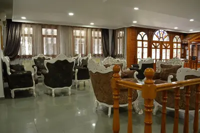 a room with chairs and a table and windows at Atlas Otel in Bursa