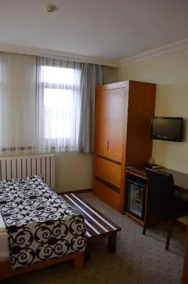 a hotel room with a bed and a desk and a television at Atlas Otel in Bursa