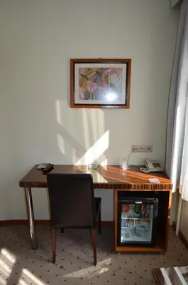 a wooden desk with a chair and a telephone at Atlas Otel in Bursa