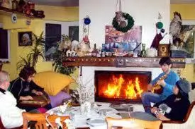 a group of people sitting in a living room with a fireplace at Gizlibahce Hotel in Karaburun