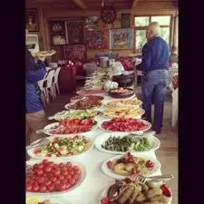 a long table with plates of food on it at Gizlibahce Hotel in Karaburun