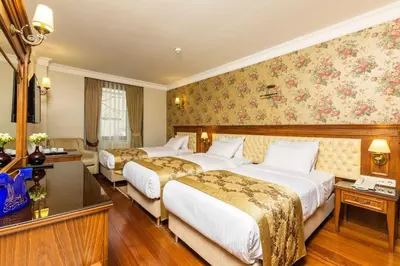 two beds in a hotel room with floral wallpaper at Acra Hotel - Special Category in Istanbul