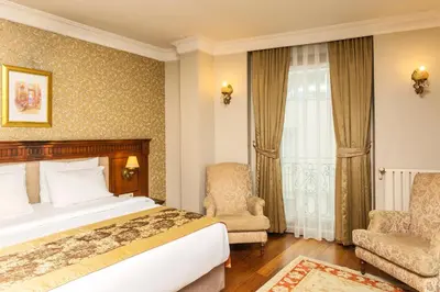 a hotel room with a bed and two chairs at Acra Hotel - Special Category in Istanbul