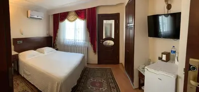 a bedroom with a bed and a window and a television at Ada Hotel Istanbul in Istanbul