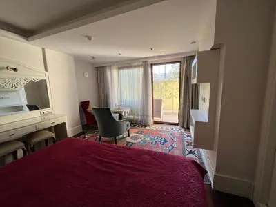a hotel room with a red bed and a desk and a window at Ada Hotel Istanbul in Istanbul