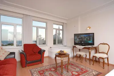 a living room with a tv and a couch and chairs at Ada Hotel Istanbul in Istanbul