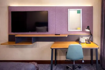 a room with a tv and a desk with a chair at Holiday Inn Sisli by IHG in Istanbul