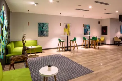 a living room with a green couch and tables and chairs at Holiday Inn Sisli by IHG in Istanbul
