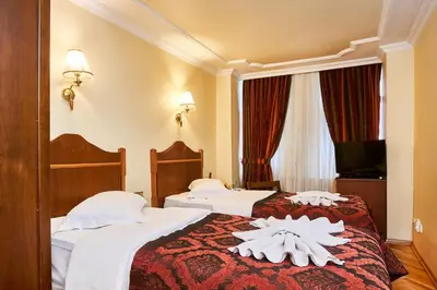 two beds in a hotel room with towels on them at Amber Hotel & Spa in Istanbul