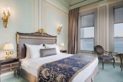a bedroom with a bed and a chair and windows at Bosphorus Palace Hotel in Istanbul